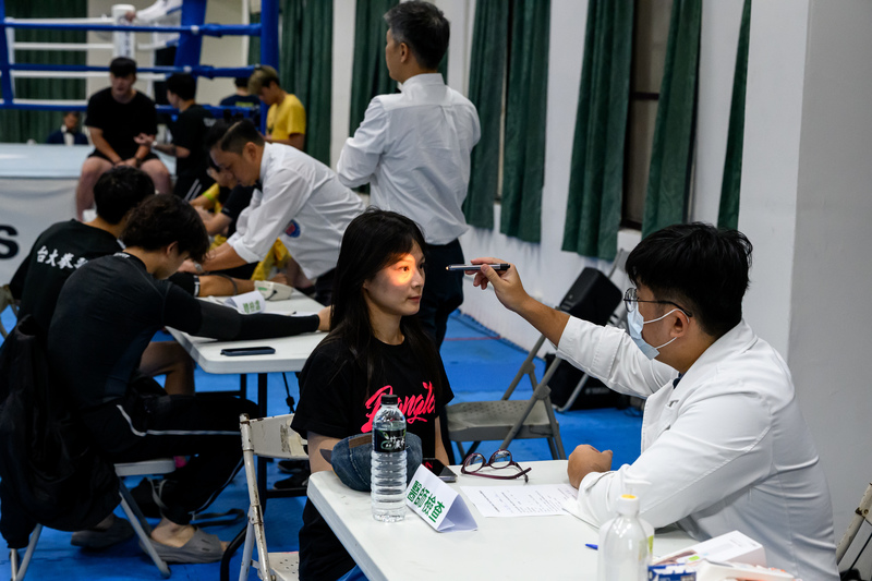 參賽選手在登台前接受醫師理學檢查。目前民間賽事多由現場醫師確認選手血壓，並詢問有無相關傷病史。（攝影／黃世澤）